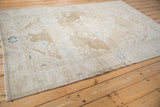 Full length view of a vintage Hamadan carpet with a distressed, neutral-toned field.