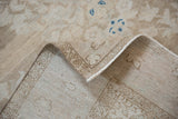 The hand-knotted back and secured side cord of a distressed beige Hamadan rug.