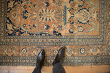 Close view of an antique Tabriz rug's floral palmettes and scrolling vine border.