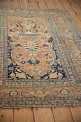 Perspective view of an antique Tabriz rug with a time-softened sandalwood and navy blue floral design.