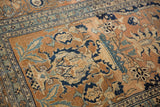 Worn pile reveals the intricate floral and vine patterns of this antique Persian Tabriz rug.