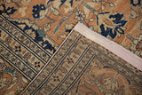 Corner of an antique Tabriz rug folded to show the wool pile and hand-knotted foundation.