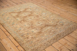 Vintage Afghan rug showing its geometric field and detailed borders in neutral tones.