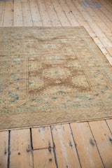 Angled view of a vintage Afghan rug highlighting its soft geometric patterns and even, low pile.