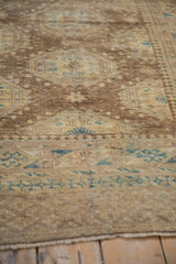 Mostly even wear shown across the low, hand-knotted wool pile of a vintage Afghan rug.