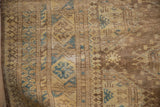 Close detail of a vintage Afghan rug's mostly even wear across its hand-knotted wool pile.