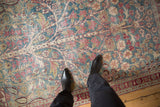 Overhead view of the worn, textured pile of a vintage Persian Meshed rug underfoot.
