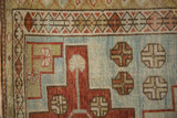Detail showing the worn knot heads and geometric designs on a distressed Caucasian rug.