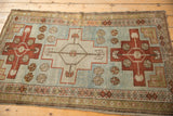 Triple stepped medallions in rust red and olive on a distressed powder blue Caucasian rug.