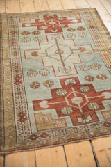 Angled view of a Caucasian rug with stepped red medallions on an abrashed powder blue field.