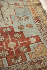 Close-up showing the mostly even wear on the geometric medallion and powder blue field of a vintage rug.