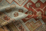 Time-softened texture of a distressed Caucasian rug with geometric designs in powder blue and rust.