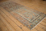 Long perspective view of a vintage Malayer runner with rust and dusty blue Herati design.