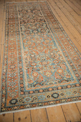 A long view down a vintage Persian Malayer runner, showing its soft wear and dusty palette.