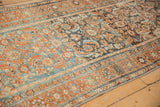 Angled view along a vintage Malayer runner showing the distressed Herati design in rust and blue.