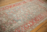 Heavy abrashes across the dusty blue and pale red field of a distressed Malayer rug.