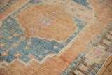Distressed vintage Northwest Persian rug detail, showing machine bound side and worn pile.
