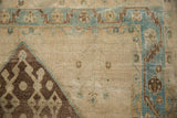 Hamadan rug detail: abrashed ivory field, sky blue serrated border, chocolate brown geometric.