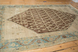 Distressed antique Hamadan rug detail: brown lattice pattern, abrashed ivory ground, serrated sky blue border.