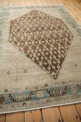 Distressed brown lattice on abrashed ivory field with sky blue serrated border.