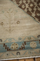 Distressed Hamadan rug detail: abrashed ivory field, subtle seed motifs, and sky blue geometric border.