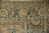 Faded dusty teal arabesque vines and serrated leaf border motif on distressed Ahar rug.