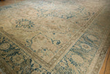 Decorative serrated leaf border and arabesque vines in dusty teal on this distressed Ahar carpet.