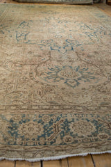 Distressed Ahar carpet displaying faded dusty teal arabesque vines and mostly even wear.