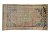 Distressed vintage Sivas carpet: faded rose field, jade green medallion, and dusty blue floral motifs.