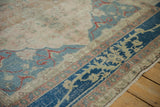 Distressed Sivas carpet, sapphire blue border, pale rose hues, and scrolling vine details.