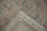 Distressed Sivas carpet pile revealing its hand-knotted foundation and muted rose and green hues.