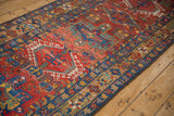 Vintage Karaja runner with geometric hook and latch motifs in brick red, blue, and gold.