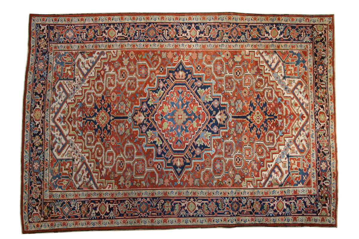 Vintage Heriz Persian carpet with a serrated diamond medallion in brick red, navy blue, and jade green.