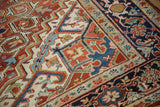 Close-up of a vintage Heriz corner with serrated spandrels and a navy turtle samovar border.