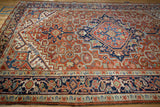 Angled view showing the geometric field and turtle samovar main border on a vintage Heriz carpet.