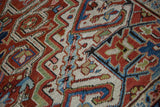 Sharp serrated motifs and visible knot heads on the hand-knotted pile of a vintage Heriz carpet.