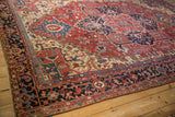 Close view of a vintage Heriz rug's navy border with red and pale blue arabesque floral motifs.