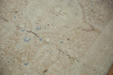 Close-up of distressed vintage Sarouk rug showing faint foundation and muted beige, blue florals.