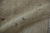 Distressed Sarouk rug with worn texture, faint patterns, and muted beige and brown tones.