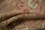 Distressed pile texture with faded ruby red and ivory geometric patterns on the vintage Anatolian rug.