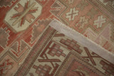 Distressed Anatolian rug corner showing geometric pattern, fringe, and hand-knotted foundation.