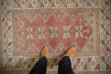 Distressed vintage Melas rug, dusty raspberry field, quatrefoil floral medallions, zigzag borders.