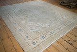 Angled perspective of a vintage square Bibikabad carpet highlighting its distressed, low-pile texture.