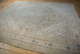 Low angle view of the Bibikabad rug's mostly even wear and distressed Herati pattern.
