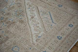 Distressed pile texture showing knot heads and blue Herati motifs on a vintage Bibikabad corner.
