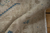 A soft fold reveals the low, textured pile of the vintage Bibikabad rug in sandy beige.