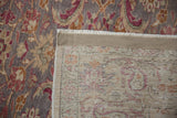 Corner of a vintage Kayseri carpet folded to reveal its hand-knotted foundation and distressed pile.