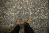Detailed view of distressed Heriz carpet with geometric leaves, palmettes in ivory, brown, and blue.