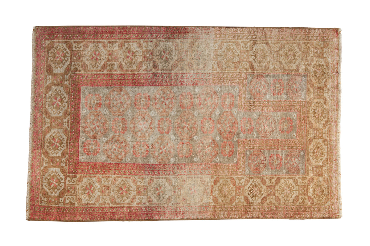 Vintage Distressed Belouch rug, prayer design with floral guls, faded raspberry, beige tones.