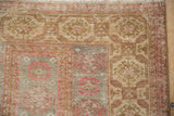 Distressed vintage Belouch rug pile, with faded raspberry guls and beige tones.